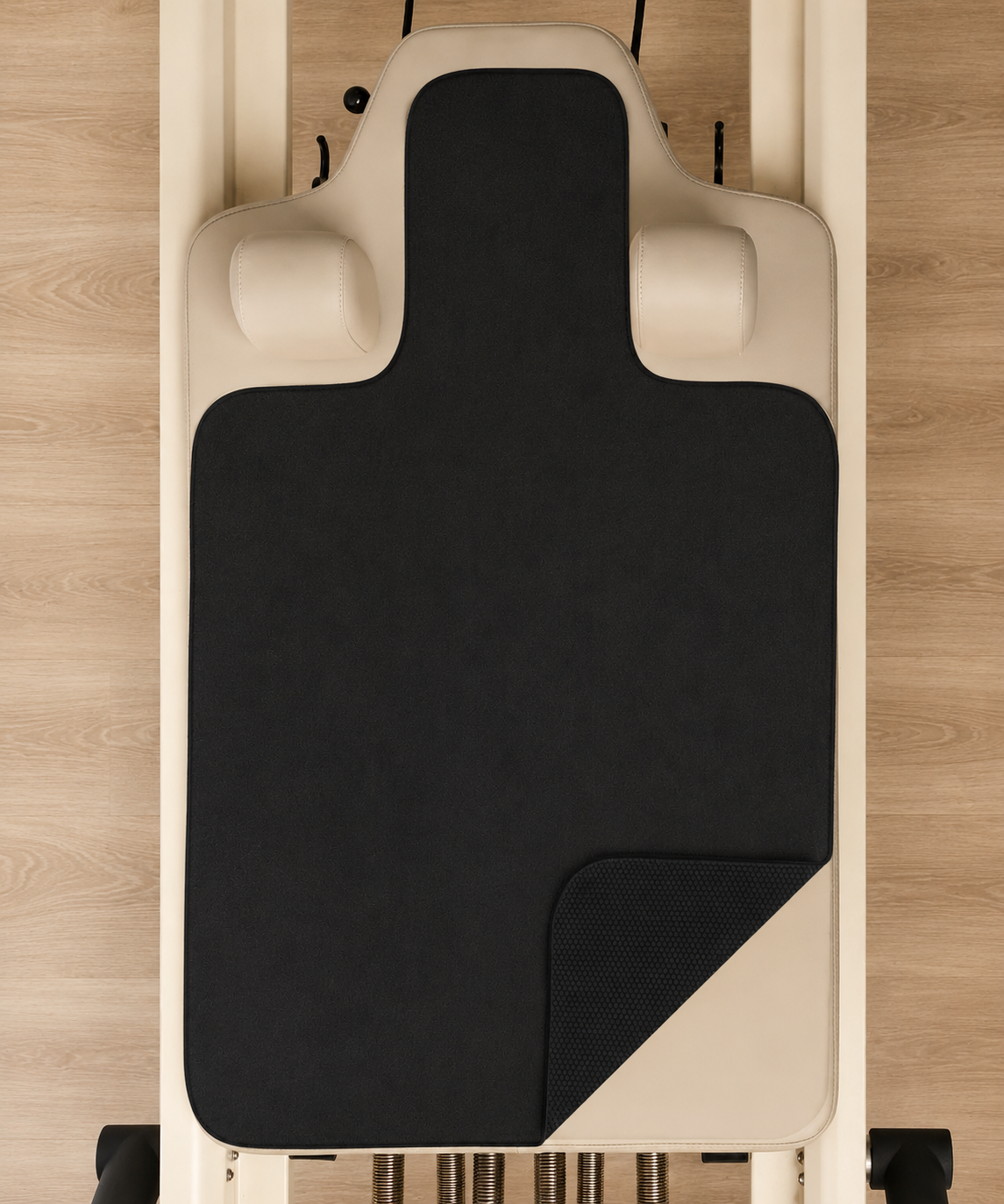 Custom branded reformer grip towel with embossed studio logo on Pilates reformer carriage