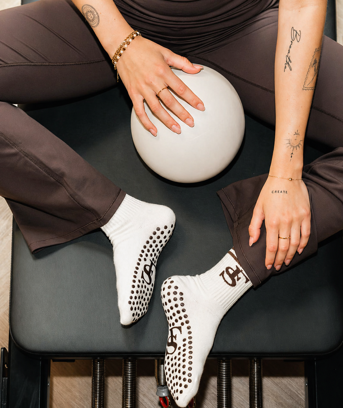 Custom Pilates grip socks with branded jacquard logo and silicone dot grip on a reformer